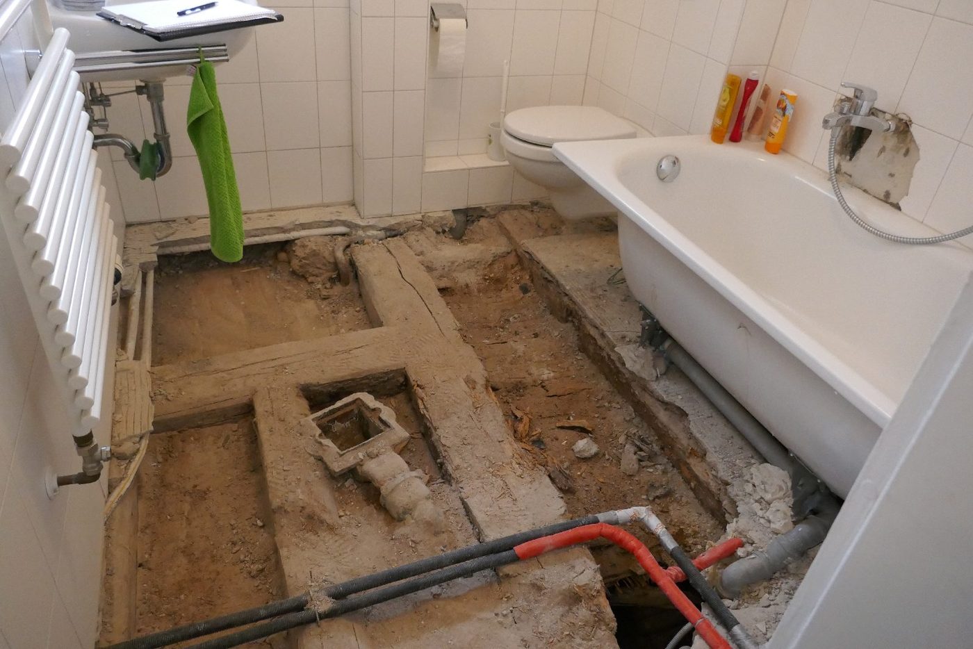 Geöffneter Badezimmerboden mit freigelegten Leitungen